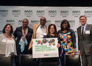 AACR President Dr. Elizabeth M. Jaffee, holding the sign, stands with speakers at the AACR’s public forum, Progress and Promise Against Cancer, held in Rosemont, Illinois, in April.