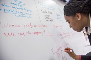 An attendee at the AACR Annual Meeting 2019 in Atlanta writes a note on the Women in Cancer Research 20th anniversary mural.