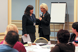 Dr. Margaret Foti, chief executive officer of the American Association for Cancer Research, and Dr. Anna D. Barker speak with Scientist↔Survivor Program participants at the American Association for Cancer Research Annual Meeting 2012 in Chicago. Photo by © AACR/Matthew Holst 2012​